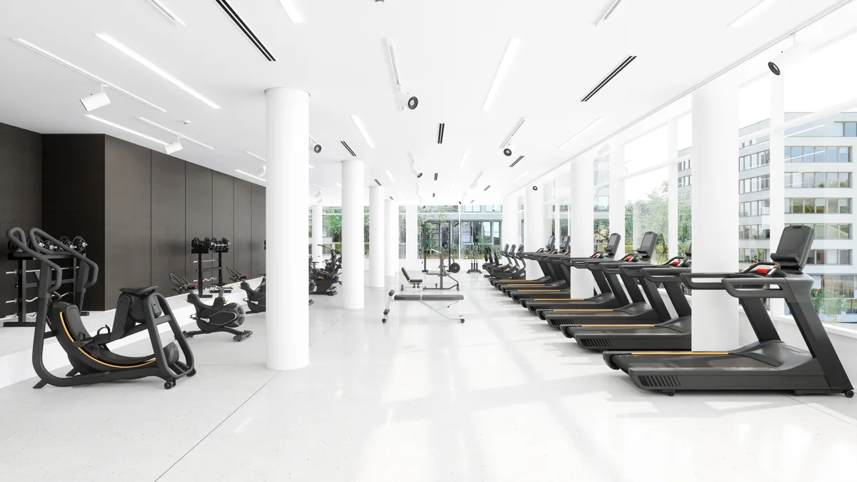 Modern gym interior with members working out on professional fitness equipment